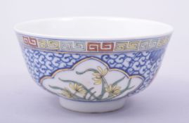 AN EARLY 20TH CENTURY CHINESE BLUE AND WHITE / POLYCHROME BOWL, the exterior decorated with flowers,