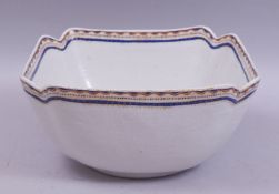 A CHINESE / EUROPEAN SQUARE FORM PORCELAIN BOWL, with red, blue and gilt work rim, 25.5cm diameter.