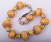 A PRESSED AMBER / BAKELITE LARGE ROUNDEL BEADED NECKLACE, with white metal mounts.