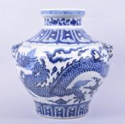 A LARGE CHINESE BLUE AND WHITE GLAZED POTTERY URN / VASE, the body painted with a dragon amongst