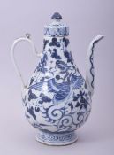 A CHINESE BLUE AND WHITE PORCELAIN LIDDED EWER, decorated with phoenix and foliate design, 25cm