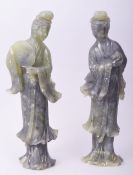 A PAIR OF CHINESE CARVED JADE STANDING FEMALE FIGURES, one carved holding a peach, the other holding