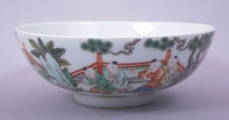 A CHINESE FAMILLE VERTE PORCELAIN BOWL, decorated with numerous figures in a garden, with eight