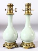 A PAIR OF CELADON PORCELAIN VASES CONVERTED TO LAMPS with brass mounts, 40cm high.