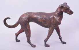 A BRONZE MODEL OF A DOG, with traces of gilt and red paint, 31cm long.