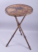 A JAPANESE LEATHER TOPPED CIRCULAR TABLE, the leather top embossed with cranes, supported on three