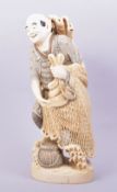 A GOOD LARGE CARVED IVORY FIGURE OF A FISHERMAN, the figure stood upon a carved wave base holding