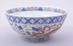 A CHINESE MING STYLE WUCAI PORCELAIN BOWL, painted with dragons and floral decoration, the base with