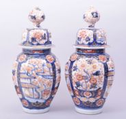 A PAIR OF JAPANESE IMARI PORCELAIN JARS AND COVERS, decorated in the imari palette with panels of