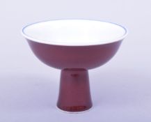 A SMALL CHINESE MING STYLE COPPER RED GLAZED STEM CUP, the interior with blue and white lotus and