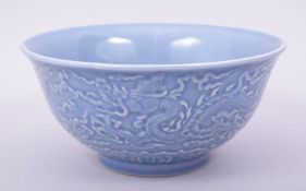 A CHINESE MING STYLE BLUE GLAZED PORCELAIN BOWL, the exterior decorated with dragons amongst