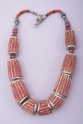 A NEPALI CORAL AND WHITE METAL NECKLACE.