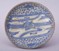 A 17TH CENTURY PERSIAN SAFAVID BLUE AND WHITE DISH, 15cm diameter.