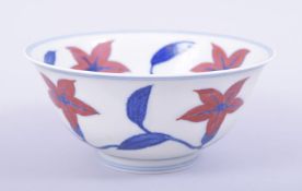 A CHINESE MING STYLE PORCELAIN BOWL, painted with large flower heads in red, six character mark to