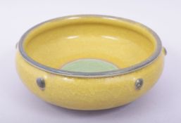 A CHINESE YELLOW AND GREEN GLAZED BOWL, the exterior with six raised bosses, 23cm diameter.
