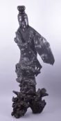 AN EARLY LARGE CHINESE ROOTWOOD CARVED GUANYIN, on a naturalistic base, 101cm high.