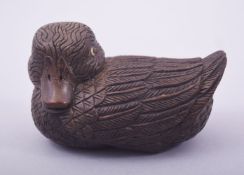 A JAPANESE CARVED WOOD MODEL OF A DUCK, with inlaid eyes and inset seal mark, 8.5cm long.