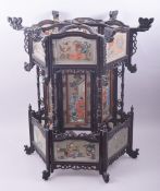 A CHINESE EBONISED WOOD AND REVERSE PAINTED GLASS PANEL LANTERN, painted with figures and native