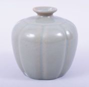 A CHINESE CELADON GLAZE RIBBED SQUAT FORM VASE, 14cm high.