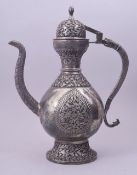 AN ISLAMIC EMBOSSED AND CHASED WHITE METAL LIDDED EWER, decorated with a panel of birds and flora