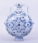 A CHINESE BLUE AND WHITE PORCELAIN TWIN HANDLE MOON FLASK, the body painted central with lotus and