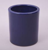 A CHINESE BLUE GLAZE PORCELAIN BRUSH POT, the base with impressed six character mark, 14cm high.