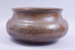 A LARGE ISLAMIC / PERSIAN ENGRAVED BRONZE BOWL, with panels of animals and flora, 38cm diameter.