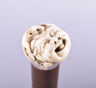 AN 18TH CENTURY JAPANESE CARVED IVORY HANDLE WALKING CANE, the handle carved with a mask and a