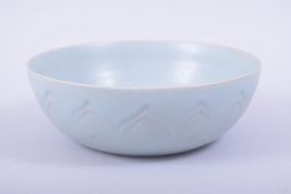 A CHINESE CELADON CIRCULAR BOWL, the exterior with incised petal design, 18.5cm diameter.
