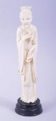 A CHINESE CARVED IVORY FIGURE OF A SAGE holding a ruyi scepter, mounted to a hardwood base, 23cm