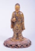 A CHINESE QING DYNASTY SOAPSTONE LOUHAN FIGURE and stand, the figure 13.5cm high.