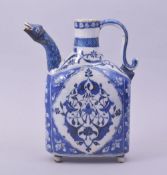 A TURKISH OTTOMAN IZNIK BLUE AND WHITE GLAZED POTTERY EWER, with zoomorphic spout, the base raised