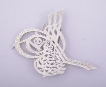 AN ISLAMIC WHITE METAL CLIP ORNAMENT.