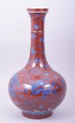 A CHINESE COPPER RED GROUND PORCELAIN VASE, decorated with blue and white dragons amongst stylised