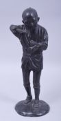 A JAPANESE MEIJI BRONZE FIGURE OF A FARMER HOLDING A PIPE, on a circular bronze base, 29.5cm high.
