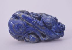 A CHINESE LAPIS LAZULI CARVING, of a monkey on bamboo with fruit, 7cm x 4cm.