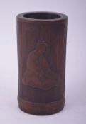 A SMALL CHINESE BAMBOO BRUSH POT, decorated with a seated figure and script, 13cm high.