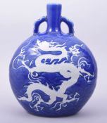 A CHINESE SACRIFICIAL BLUE PORCELAIN TWIN HANDLE MOON FLASK, the body decorated with a white