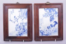 A PAIR OF EARLY 20TH CENTURY FRAMED BLUE AND WHITE PORCELAIN PLAQUES, the panels depicting a