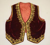 A KURDISH RED VELVET WAISTCOAT, with embroidered gilt thread decoration.