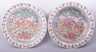 TWO LARGE CHINESE EXPORT PORCELAIN CHARGERS, painted with European scenes depicting figures on