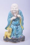 A MING STYLE FAHUA LOUHAN WITH LION FIGURE, the figure with the head and hands unglazed, 21.5cm
