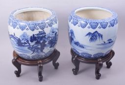 A PAIR OF JAPANESE BLUE AND WHITE PORCELAIN HIBACHIS on hardwood footed stands, each decorated