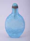 A CHINESE BLUE TINTED CUT GLASS SNUFF BOTTLE AND STOPPER, decorated with the longevity symbol and