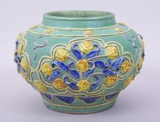 A CHINESE MING STYLE FAHUA JAR, with raised decoration depicting panels of flowers, 17cm high,