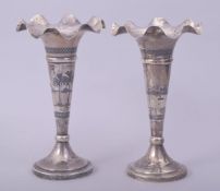 A PAIR OF IRAQI SILVER AND NIELLO FLUTED VASES, each signed, 17.5cm high.
