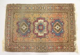 A SMALL PERSIAN RUG, rust ground with three medallions. 4ft x 2ft 8ins.
