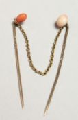 TWO GOLD AND CORAL STICK PINS.