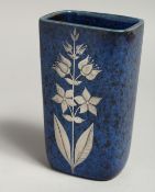A SMALL BLUE MOTTLED VASE with sliver flowers. 5ins high.