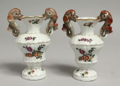 A PAIR OF 18TH CENTURY BUEN RETIRO PAINTED VASES with dolphin handles painted with flowers on each